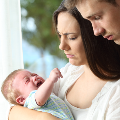 Worried parents holding their crying baby